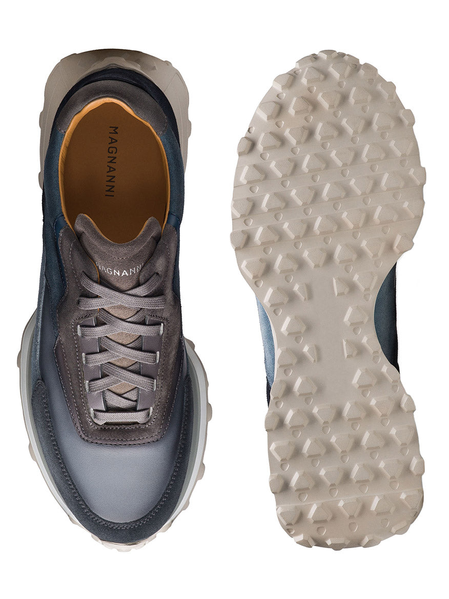 The Magnanni Onyx in Navy/Grey features a luxurious design with "Magnanni" on the blue and gray left shoe's top and the textured sports sole on the right shoe.