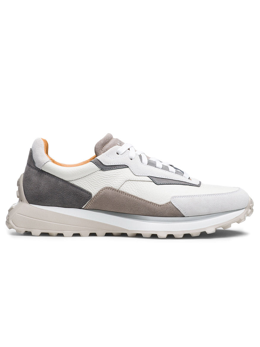The Magnanni Onyx in White/Grey is a luxury sneaker showcased in a side profile on a white background, featuring a textured sole and crafted from leather and suede materials.