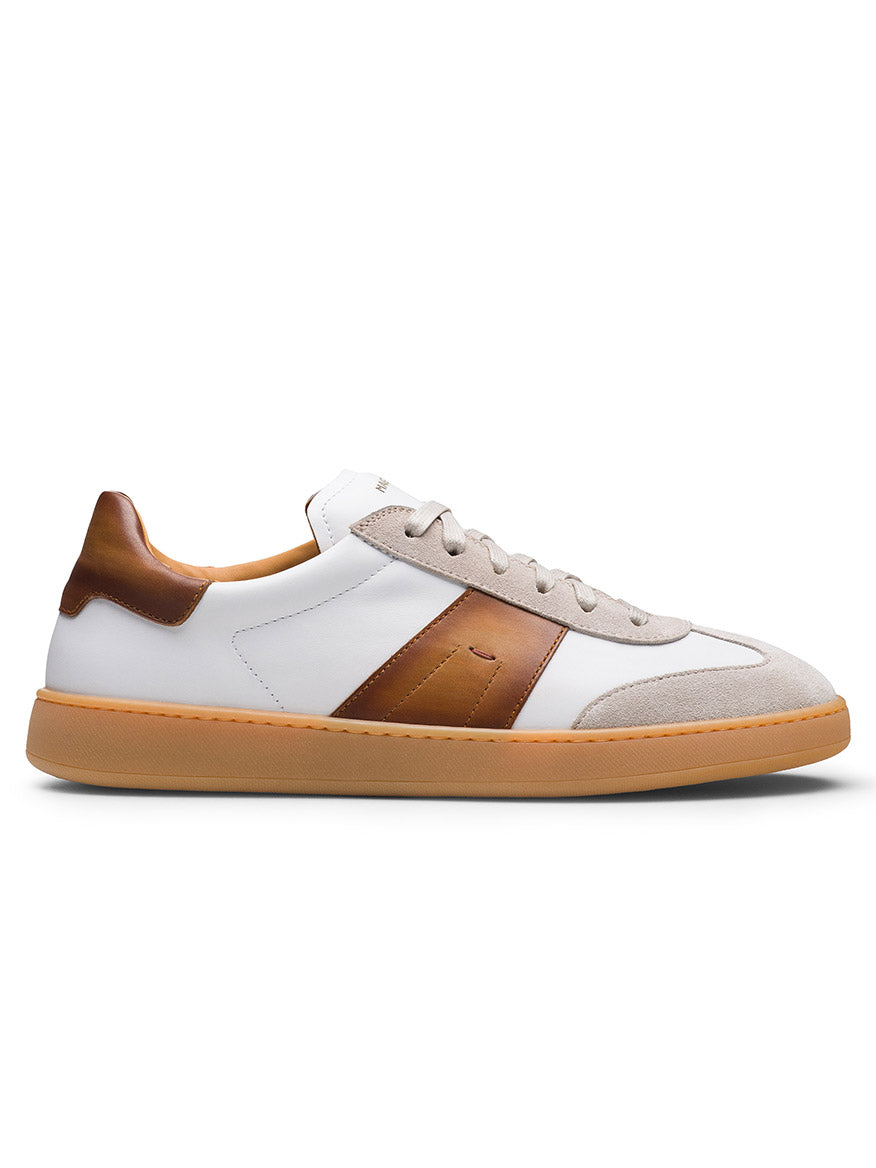Introducing the Magnanni Primera in White/Cuero: a low-top sneaker with a white upper, brown leather accents, premium beige suede toe detail, beige laces, and a gum sole—blending style and comfort effortlessly.