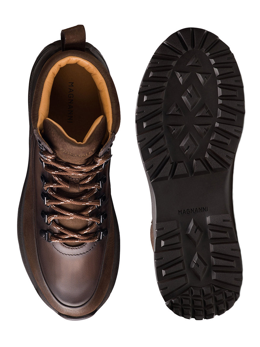 Magnanni Strata in Tumbled Brown Nubuck luxury hiking boot, handmade in Portugal and shown from above and the sole, features thick tread, two-tone laces, and prominent Magnanni branding inside and on the sole.