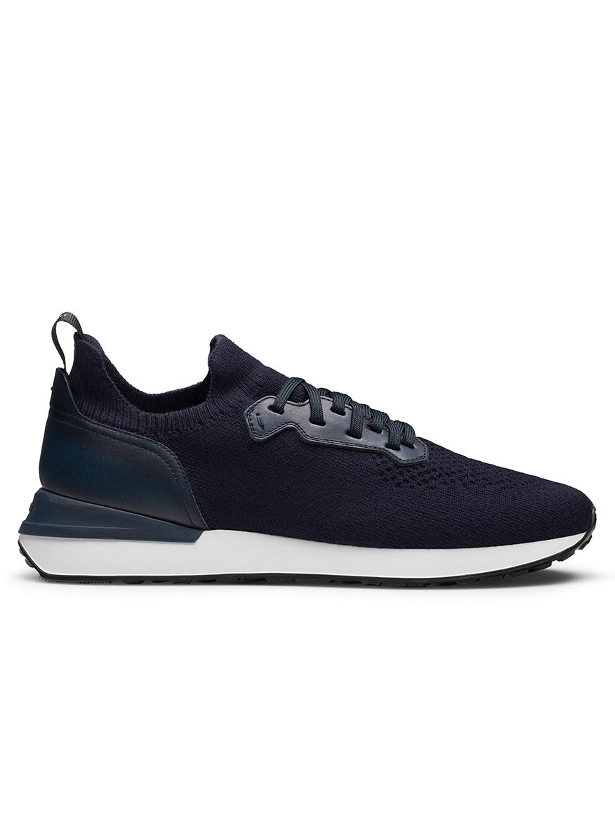 The Magnanni Stratus LyteKnit in Navy is a knit sneaker with a cushioned footbed, white sole, black outsole, knitted upper, and lace-up closure, shown in side profile.