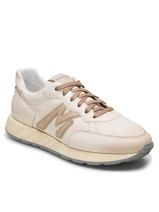 The Magnanni Yoki in White/Cream is a cream and beige sneaker with tan laces and a prominent "M" logo on the side, featuring an athletic retro-style sole with a textured design for a timeless look.