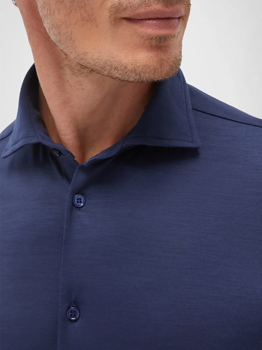 A close-up of a man wearing the Maurizio Baldassari Santini Techmerino Wool Shirt in Blue, showing his jawline, part of his mouth, and neck.