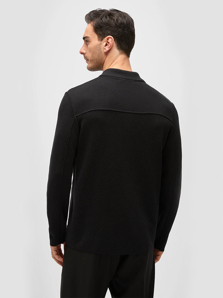 Rear view of a man wearing a Maurizio Baldassari Silk & Cotton Overshirt in Black, standing against a light gray background.