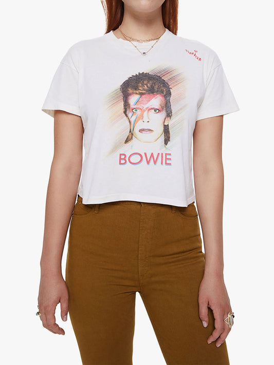 Sentence with Product Name: Woman wearing a white Mother Denim The Grab Bag Crop in Rebel Rebel with "Ziggy Stardust" and David Bowie's iconic lightning bolt makeup design printed on it.