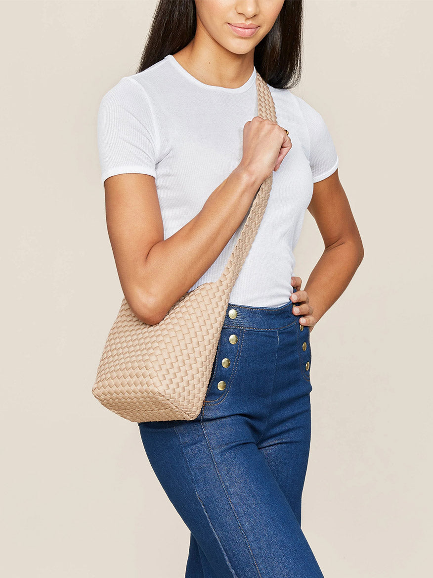 Woman posing with a Naghedi Laguna Crossbody in Solid Camel.