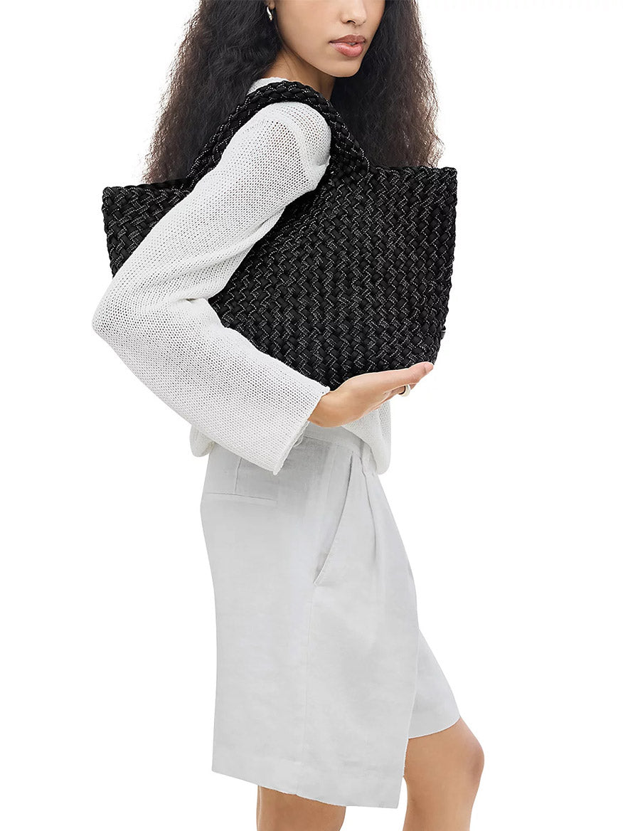 Person carrying a jet Naghedi St. Barths Medium Double Weave Tote under their arm.