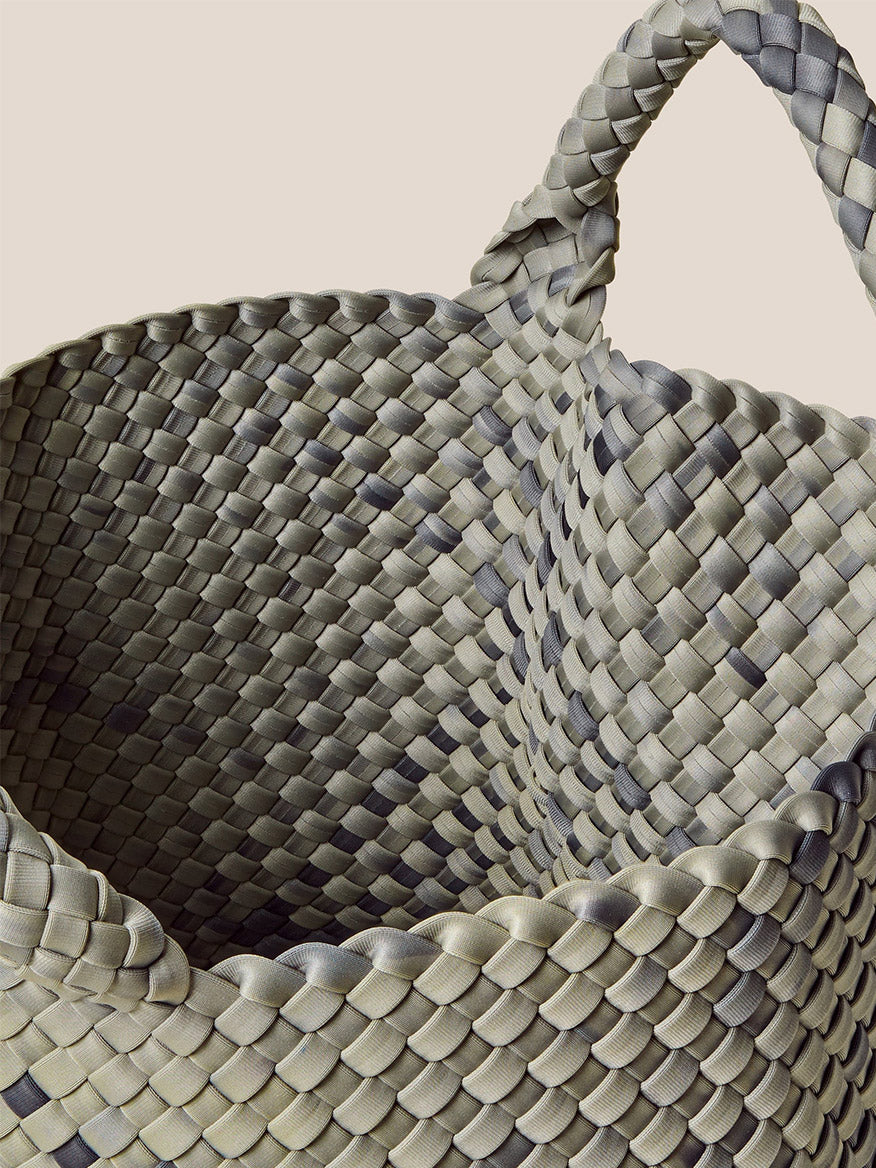 Close-up of the Naghedi St. Barths Medium Tote in Watercolor Neptune, featuring a checkered pattern in shades of gray and green, with a curved handle. This handwoven neoprene everyday bag is both stylish and functional.