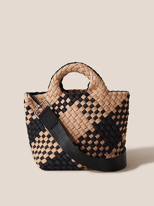 Woven tote bag in black and beige with a solid black shoulder strap, displayed against a light beige background as the Naghedi St. Barths Petit Tote in Plaid Cabana.