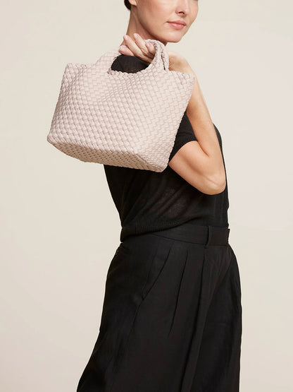 Woman posing with a Naghedi St. Barths Small Tote in Solid Shell Pink.