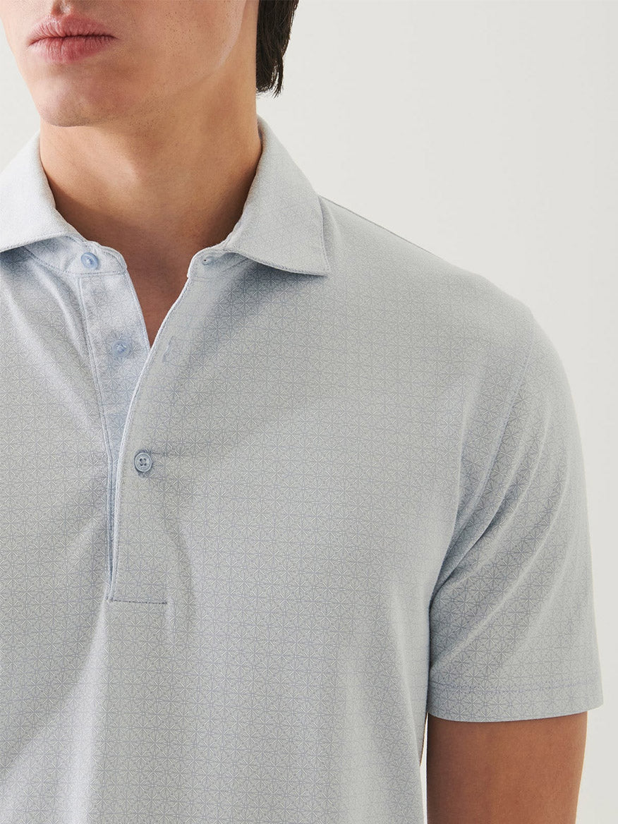 A person wearing the Patrick Assaraf Pima Cotton Stretch Printed Polo in Blue Ice, a soft short-sleeve shirt with a subtle geometric pattern, shown from shoulders to mid-chest.