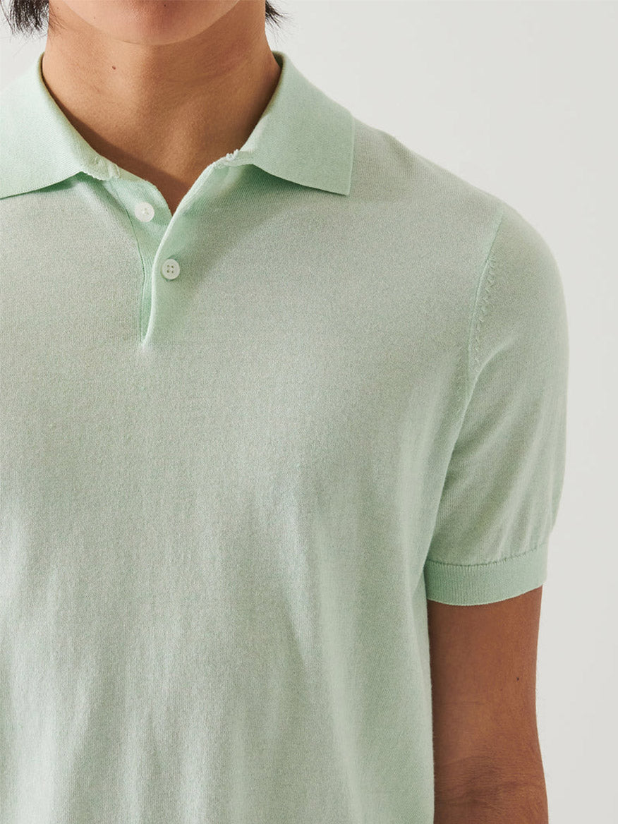 Close-up of a person wearing a Patrick Assaraf Cotton Cupro Polo in Lime, focusing on the collar and upper chest area.