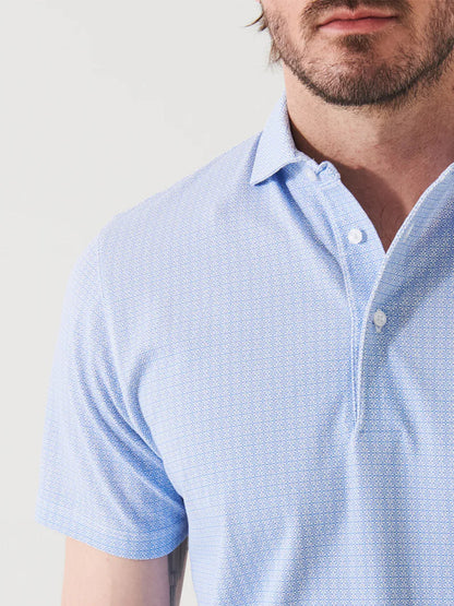 Close-up of a man in a Patrick Assaraf Pima Cotton Stretch Printed Polo in Blue Ice Mini Geo Floral Tile, focusing on the shirt's texture and the top of his chest.