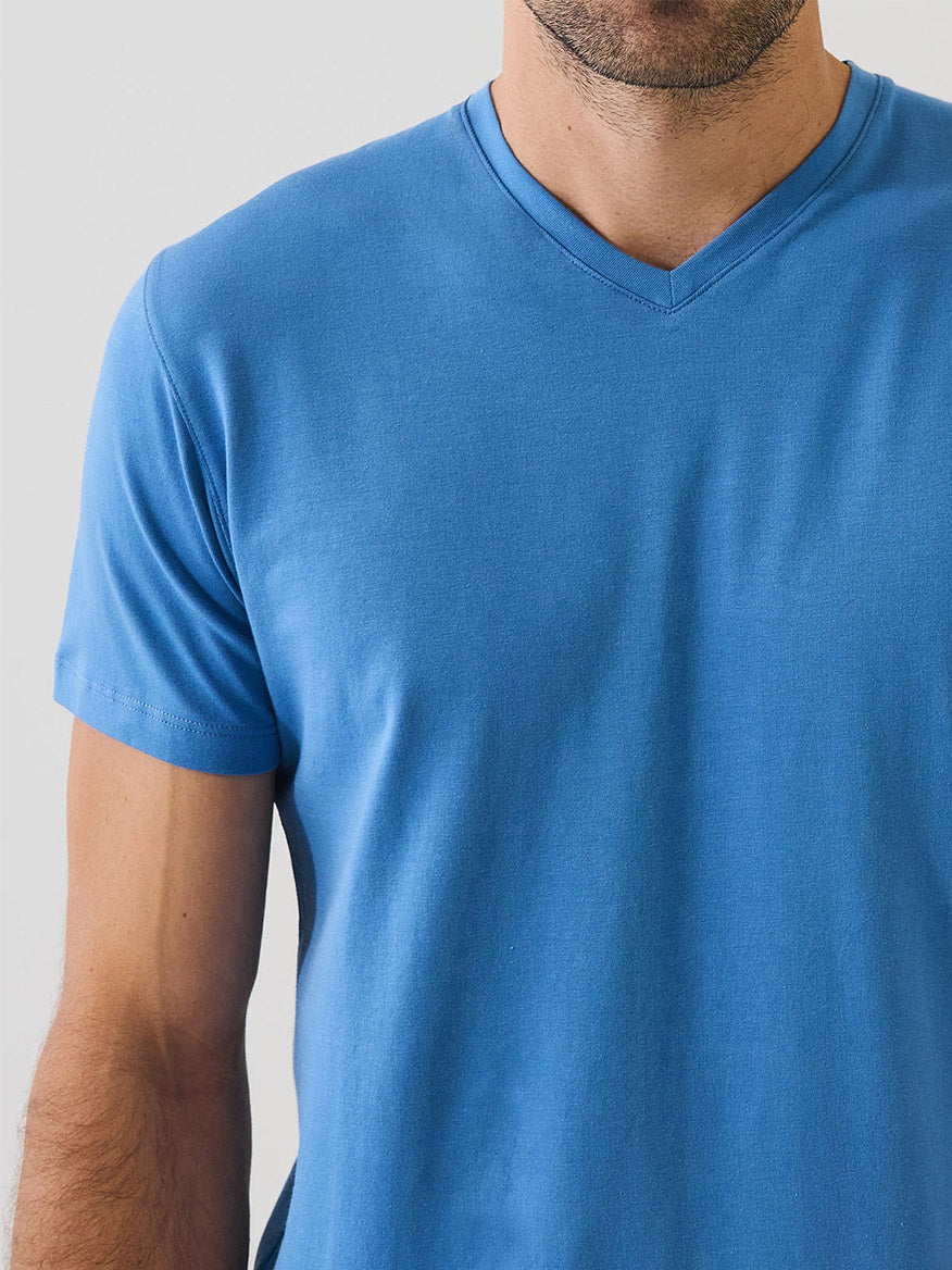 A man wearing the Patrick Assaraf Pima Cotton Stretch V-Neck T-Shirt in Harbour stands against a neutral background, with only his upper torso visible.