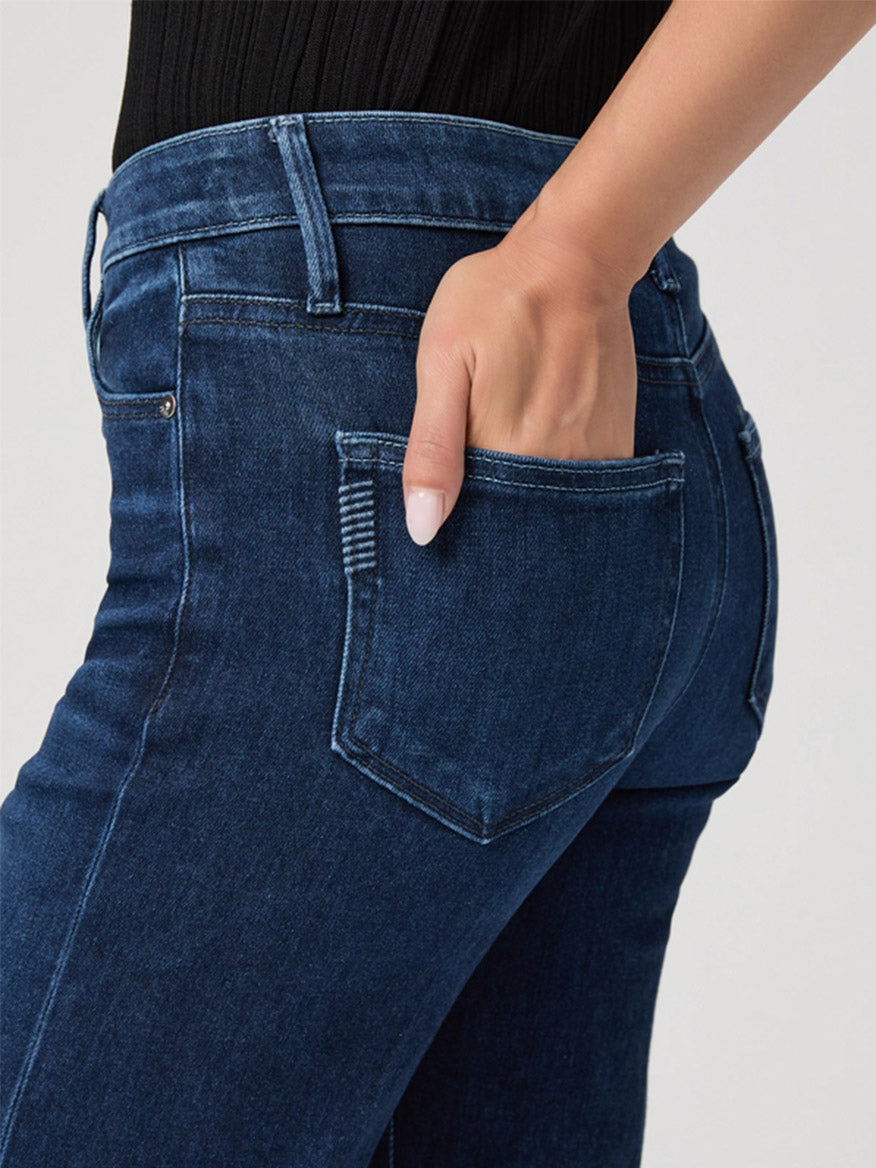 A person wearing the Paige Leenah Petite Wide Leg Jean in Praline with their right hand placed in the back pocket.