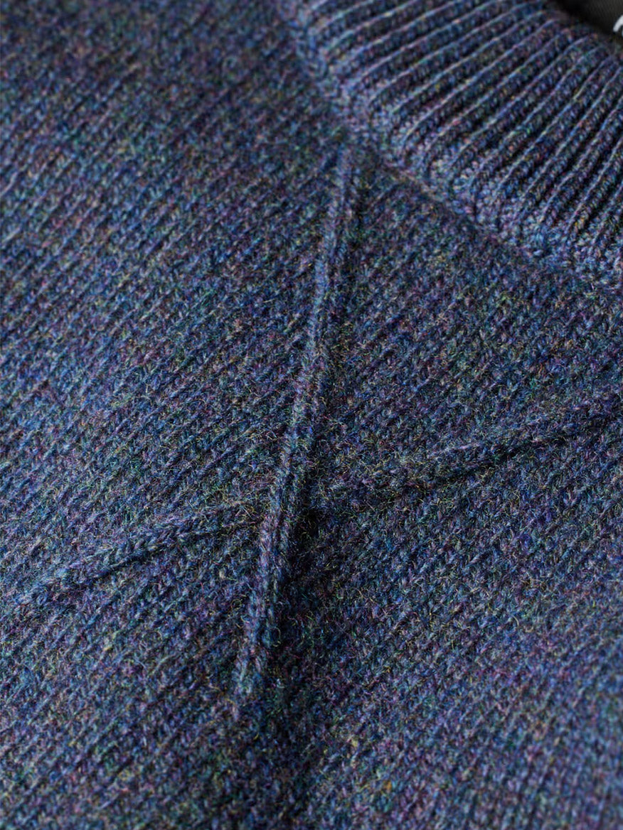 Close-up of the Paul Smith Indigo Merino Wool Crew Neck Sweater, featuring a textured blue-green knit with a ribbed collar and diagonal pattern details.
