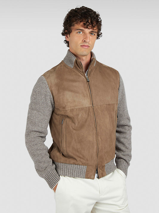 A man wearing the Paul & Shark Hybrid Zip-Up Cardigan in Natural with white pants stands against a plain light gray background.