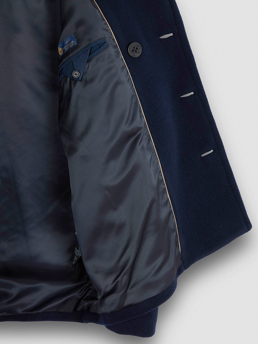 The Paul & Shark Peacoat in wool and cashmere in navy is turned inside out to reveal its smooth, shiny inner lining, an interior pocket with button closure, and contrast piping along the edge.