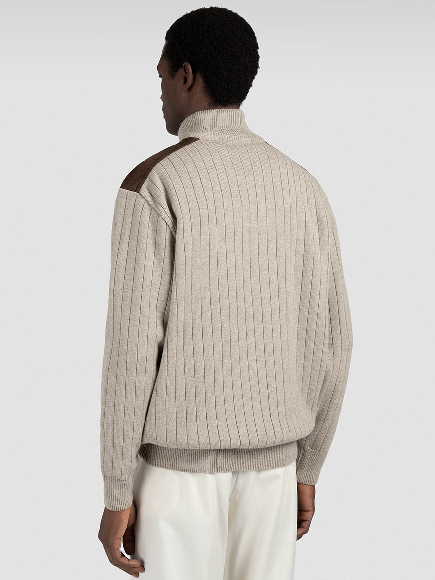 A person is seen from the back in a Paul & Shark Quarter Zip Sweater With Suede Details in natural beige, featuring brown suede shoulder patches, paired with white pants against a plain light background.