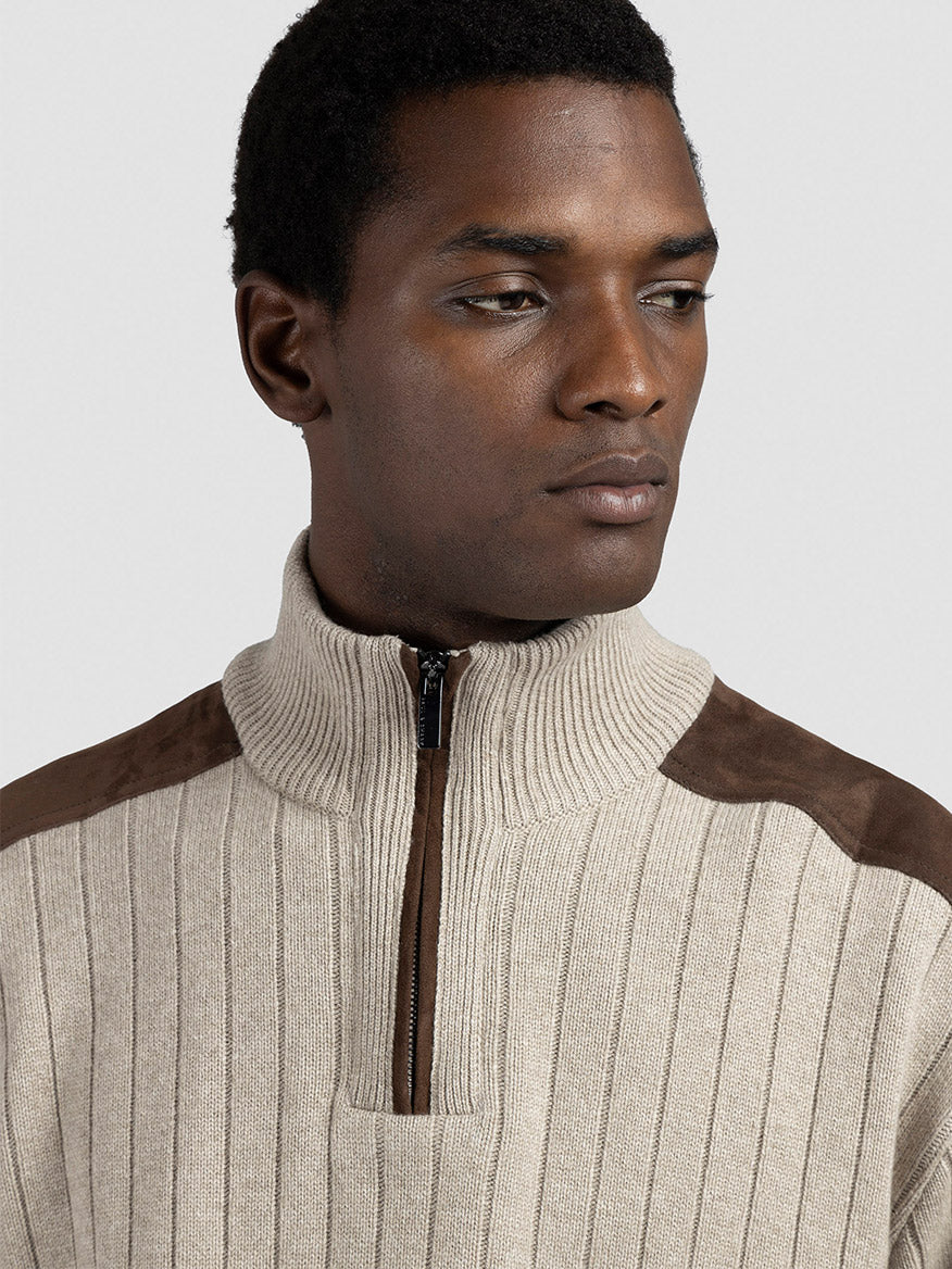A man wears the Paul & Shark Quarter Zip Sweater With Suede Details in Natural and looks to his left against a plain background.