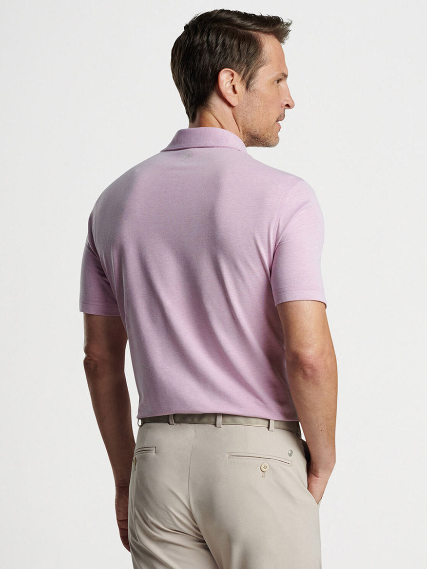Man wearing a Peter Millar Albatross Cotton Blend Piqué Polo in Valencia and beige pants viewed from behind.