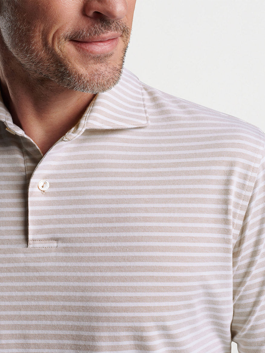 Close-up of a man wearing a striped Peter Millar Albatross Cotton Blend Piqué Polo in Summer Dunes, partial view of his face showing a smile.