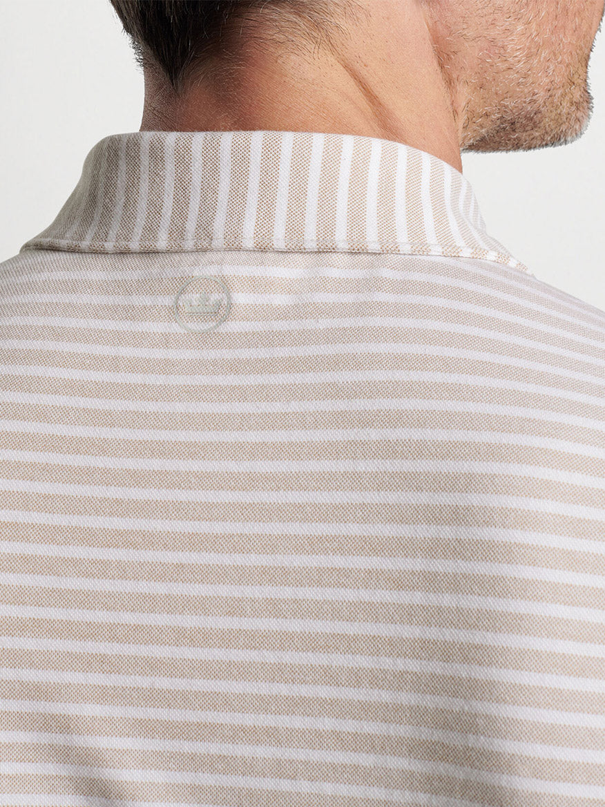 Close-up of a man wearing a Peter Millar Albatross Cotton Blend Piqué Polo in Summer Dunes with a buttoned collar from the rear view.