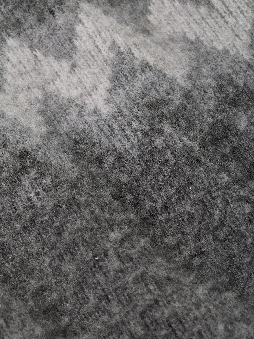 Close-up of a fuzzy Peter Millar Après-Ski Crewneck Sweater in Fossil, featuring an abstract pattern of dark and light gray knit fabric.