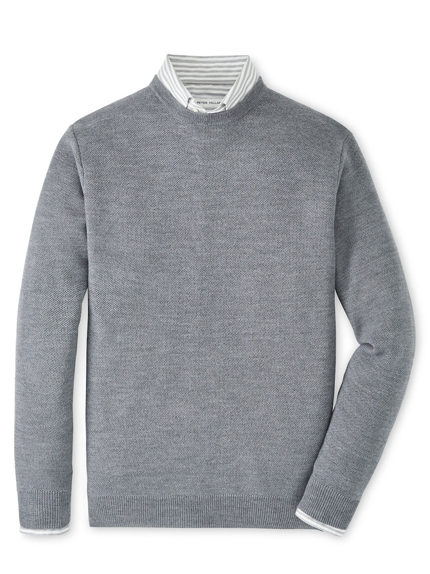 The Peter Millar Autumn Crest Honeycomb Crewneck Sweater in Gale Grey is layered over a white and gray striped collared shirt, displayed on a white background.