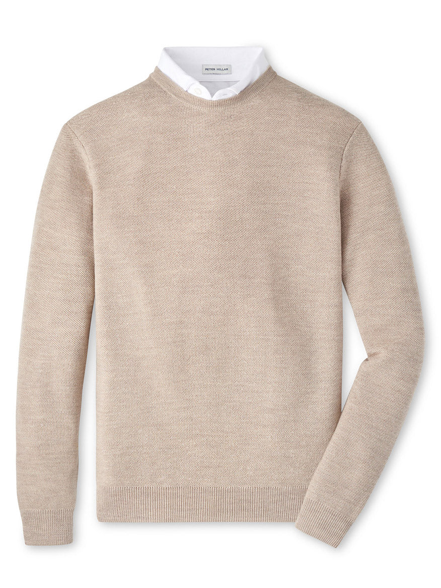 The Peter Millar Autumn Crest Honeycomb Crewneck Sweater in Light Elm, featuring a beige Merino wool design, is layered over a white collared shirt and laid flat on a white background.