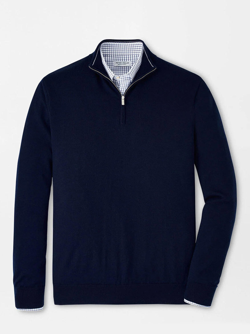 The Peter Millar Autumn Crest Quarter-Zip in Navy, crafted from Merino and lyocell in a classic fit, is layered over a light blue and white checkered dress shirt and shown on a plain white background.