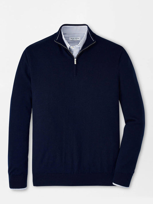 The Peter Millar Autumn Crest Quarter-Zip in Navy, crafted from Merino and lyocell in a classic fit, is layered over a light blue and white checkered dress shirt and shown on a plain white background.