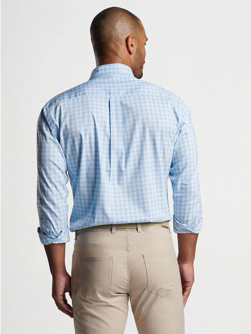 A man viewed from behind wearing a blue checkered Peter Millar Bethel Crown Lite Cotton-Stretch Sport Shirt in Cottage Blue and beige cotton-performance twill pants.