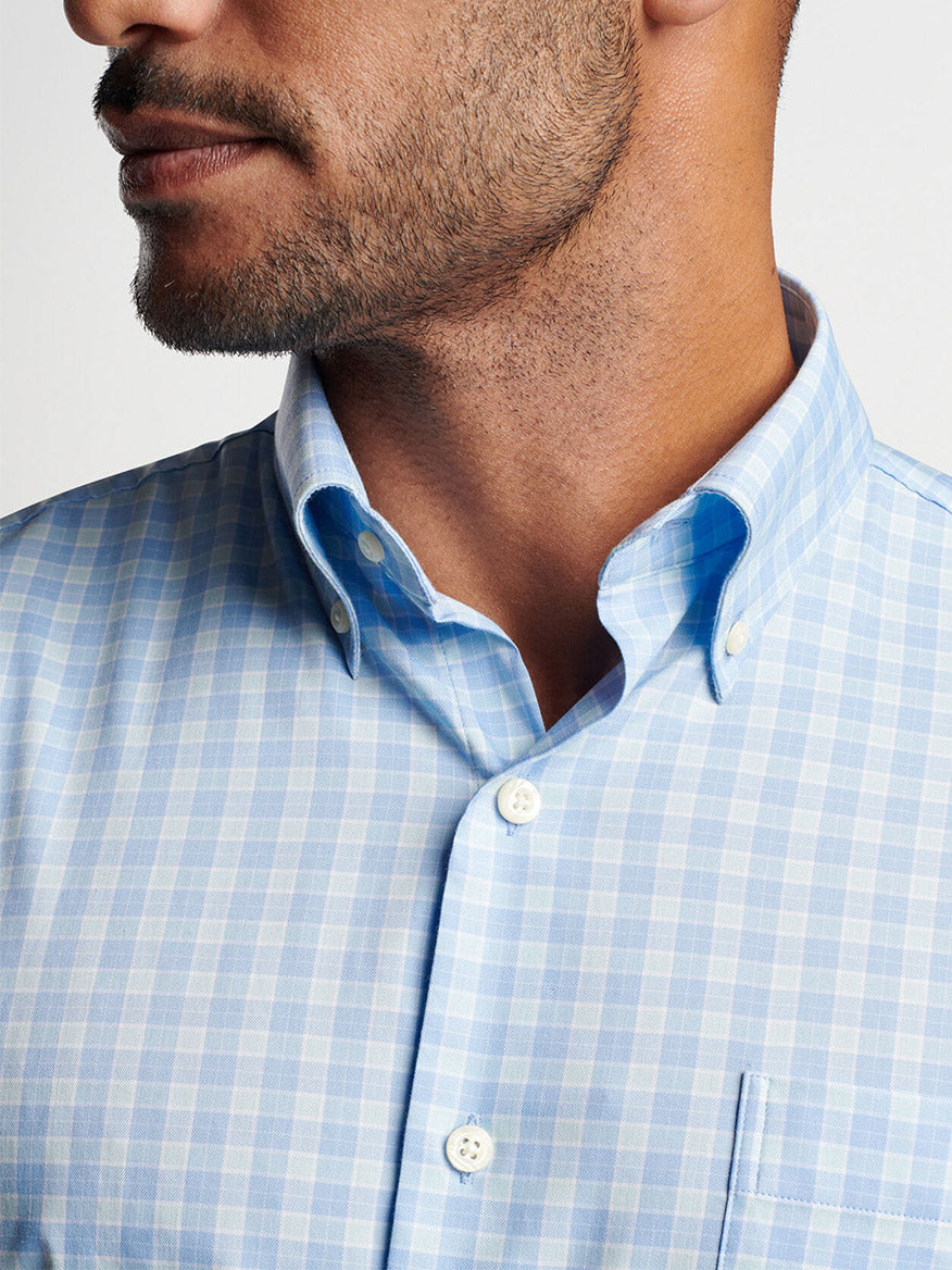 Close-up of a man in a Peter Millar Bethel Crown Lite Cotton-Stretch Sport Shirt in Cottage Blue with top button undone.