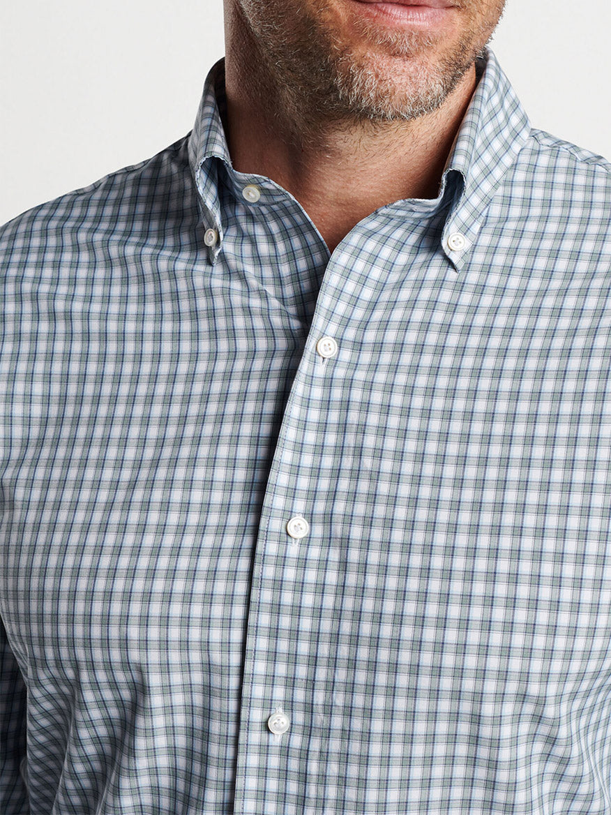 Close-up of a man wearing a Peter Millar Cole Performance Poplin Sport Shirt Sage Fog, focusing on the collar and part of the chest.