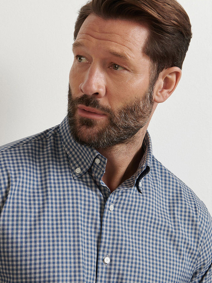 A man with short brown hair and a beard wears the Peter Millar Conway Crown Lite Cotton-Stretch Sport Shirt in Gale Grey, looking slightly to his left against a plain background.