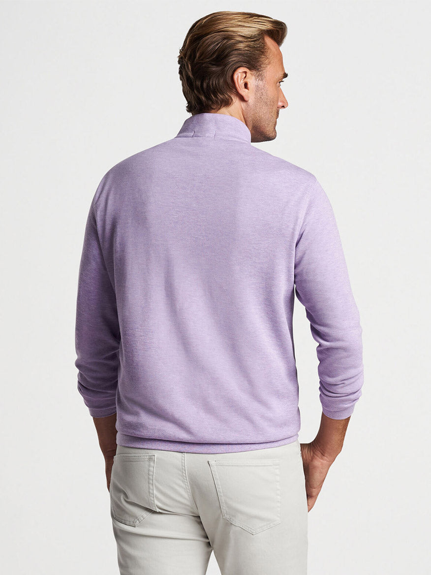 Man wearing a Peter Millar Crown Comfort Pullover in Wild Lilac and light-colored pants viewed from behind.