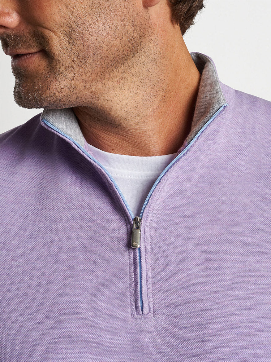 Close-up of a man wearing a Peter Millar Crown Comfort Pullover in Wild Lilac with a white collar shirt underneath.
