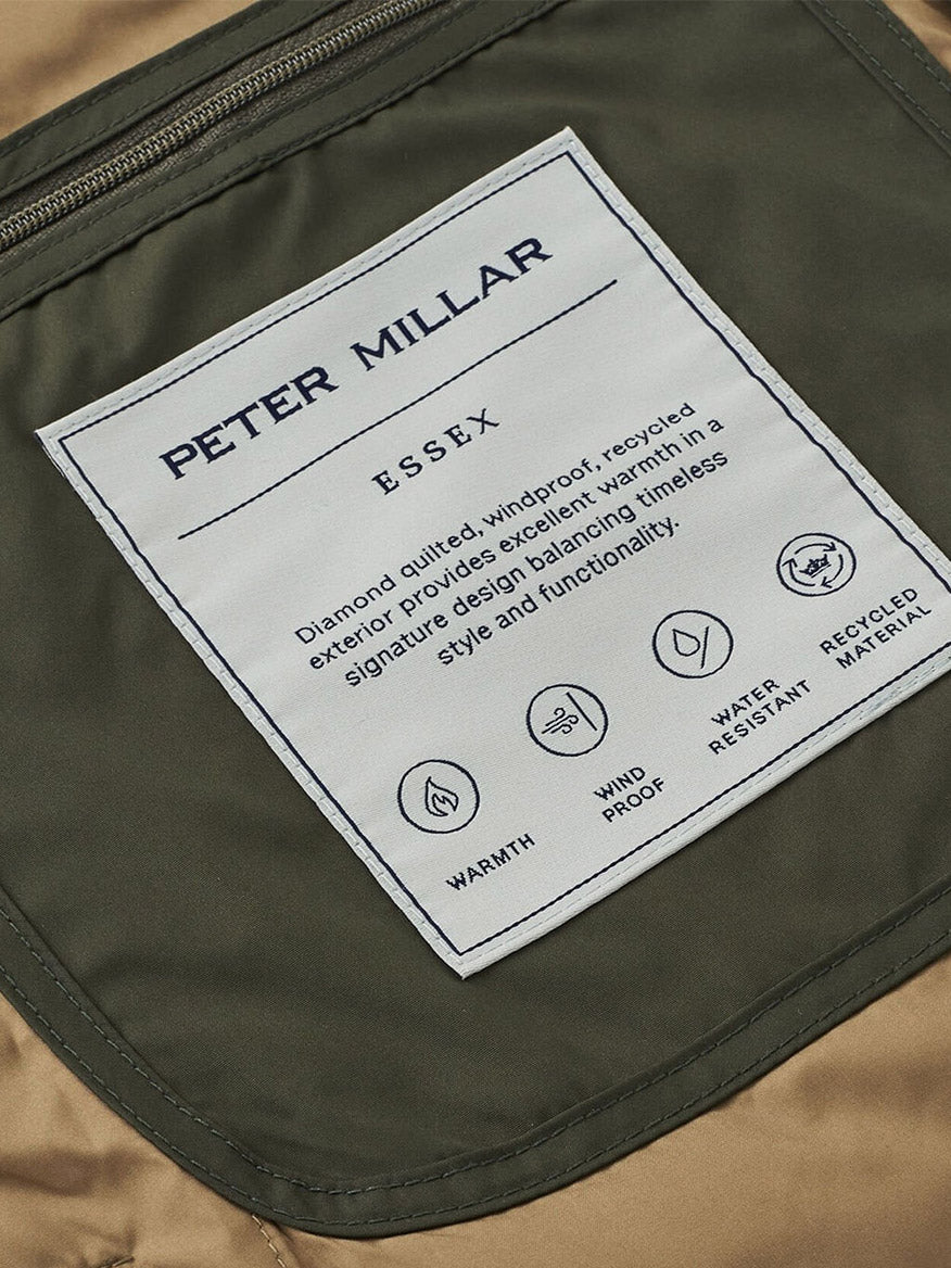 Close-up of the Peter Millar Essex Vest in Dark Olive label, showcasing its diamond quilting, windproof and water-resistant design, warmth, and use of recycled materials.