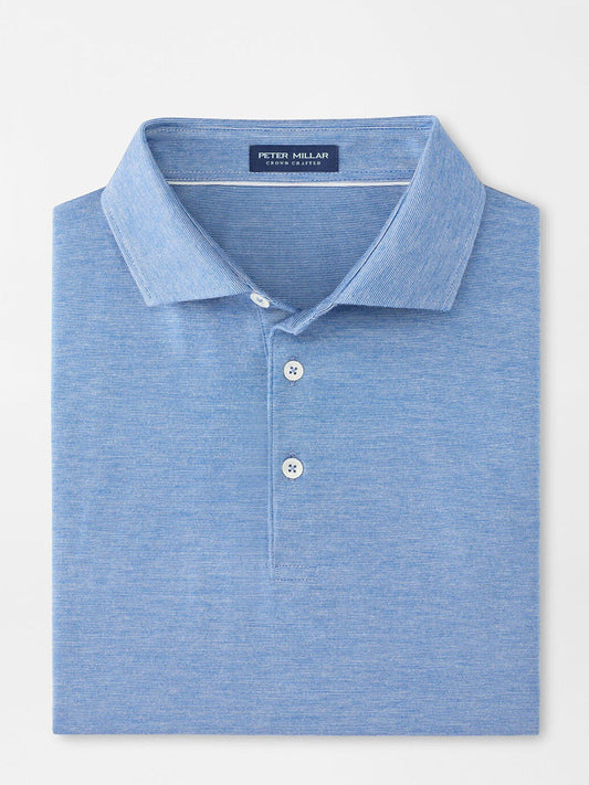 The Peter Millar Excursionist Flex Polo in Nordic Blue, made from cotton-based jersey with four-way stretch, has a classic collar and three white buttons, and is shown neatly folded on a plain background.