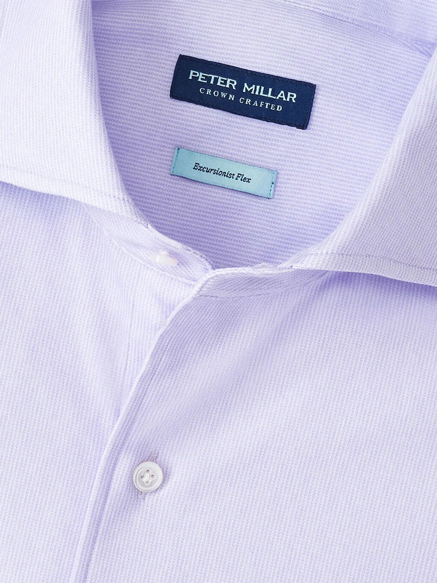A close-up of the Peter Millar Excursionist Flex Micro Print Shirt in Wisteria, featuring a pointed collar, white buttons, and a label reading "Crown Crafted" and "Beaverbrook Flex," emphasizing its comfortable, tailored fit.