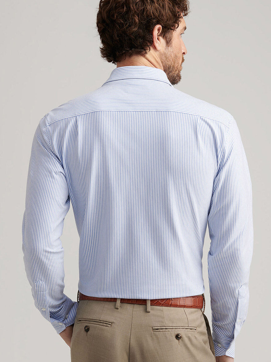 A man is shown from the back wearing the Peter Millar Excursionist Flex Stripe Sport Shirt in Rain Cloud with beige trousers.