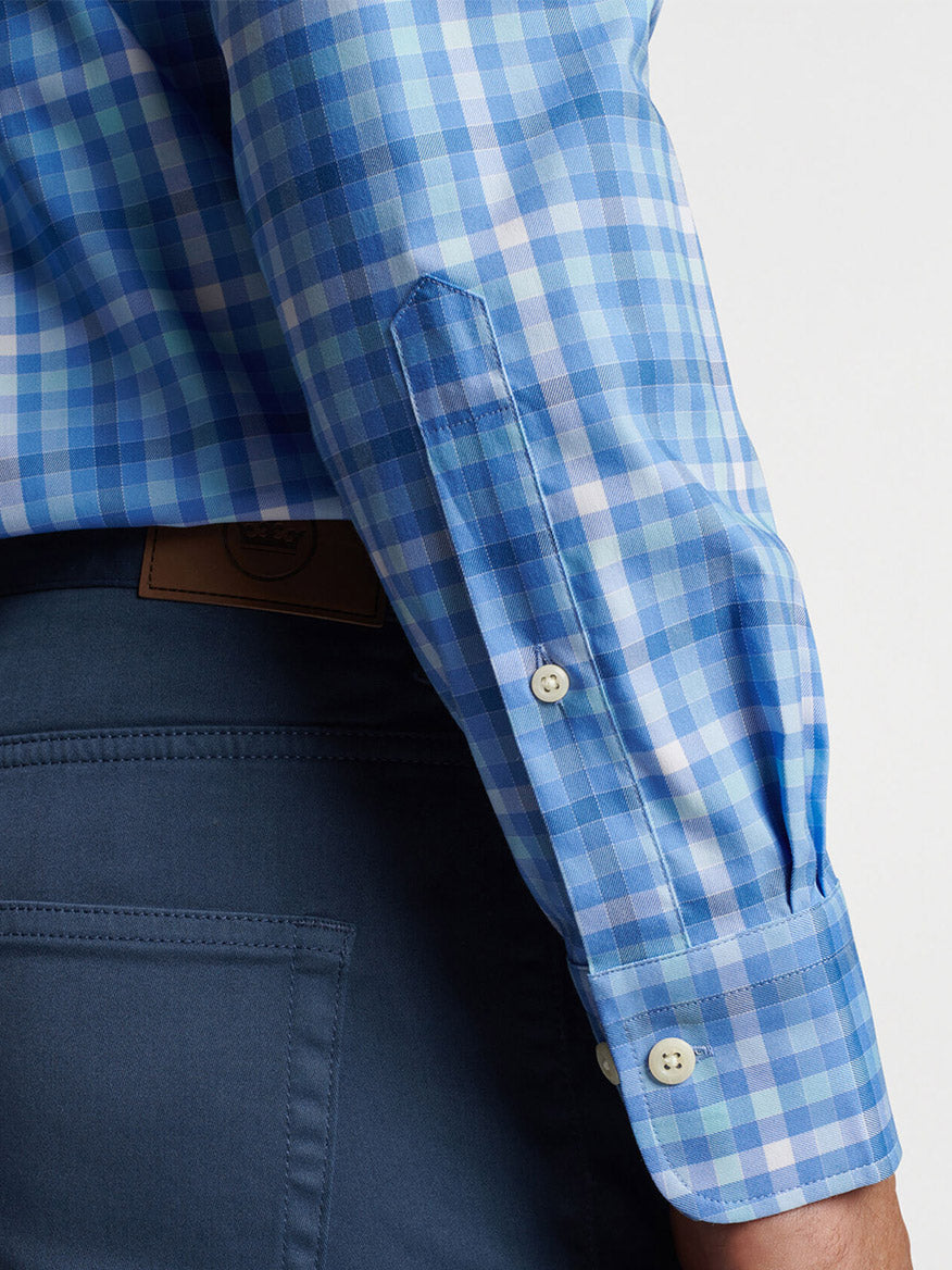 Close-up of a person wearing a Peter Millar Freeport Crown Lite Cotton-Stretch Sport Shirt in Maritime with a rolled-up sleeve and dark blue trousers, focusing on the arm and waist area.