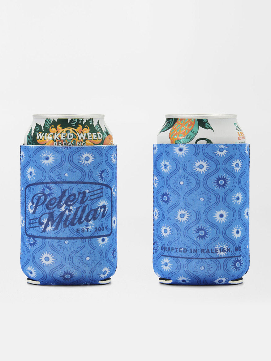 Two canned beverages in blue koozies featuring a seashell print pattern, labeled "Peter Millar" and "Crafted in Raleigh," matching the Peter Millar Hatteras Harvest Swim Trunk in Ocean Blue.