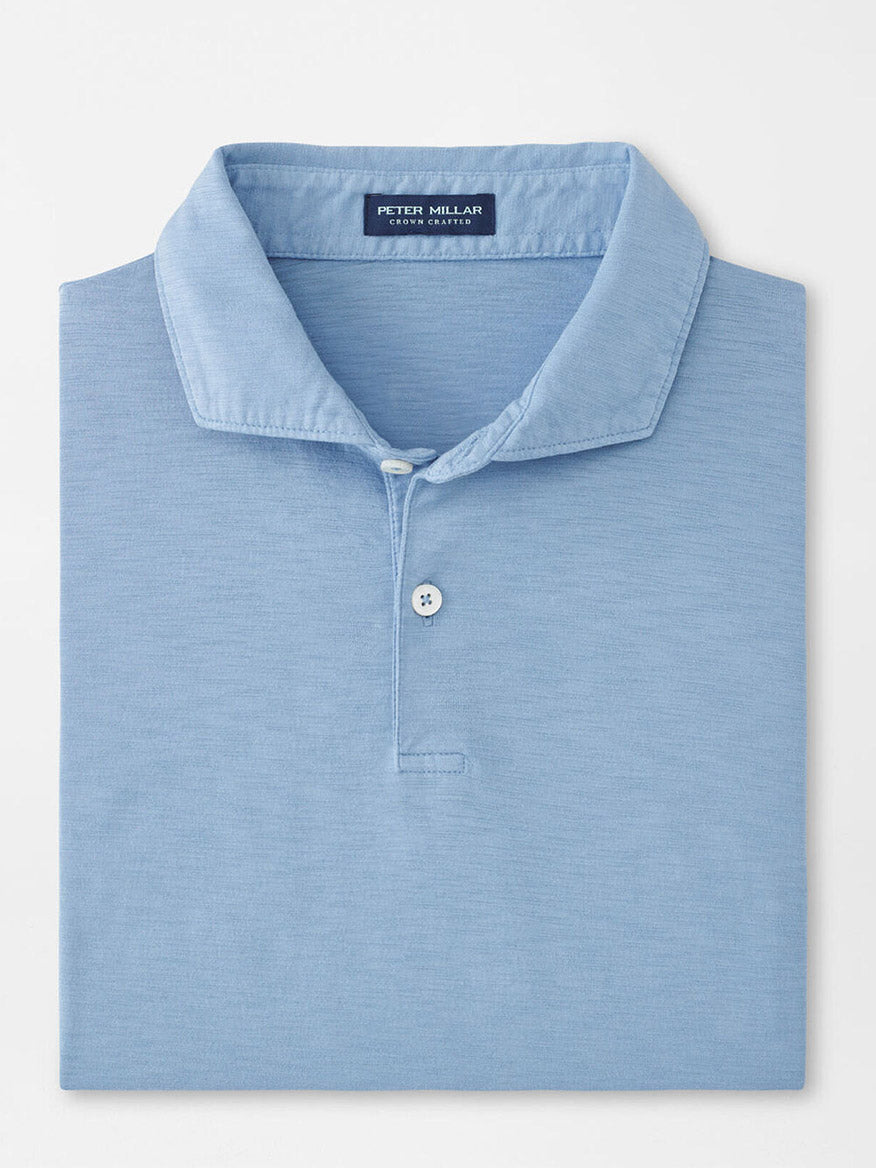A folded Peter Millar Journeyman Short Sleeve Polo in Angelite—light blue, lightweight and casual, featuring a collar, two buttons, and an inside neck label.