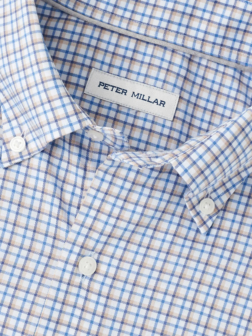 Close-up of the Peter Millar Julian Crown Lite Cotton-Stretch Shirt in Evening Tide, showcasing a blue and beige plaid pattern, collar, white buttons, and easy-care fabric for effortless style.