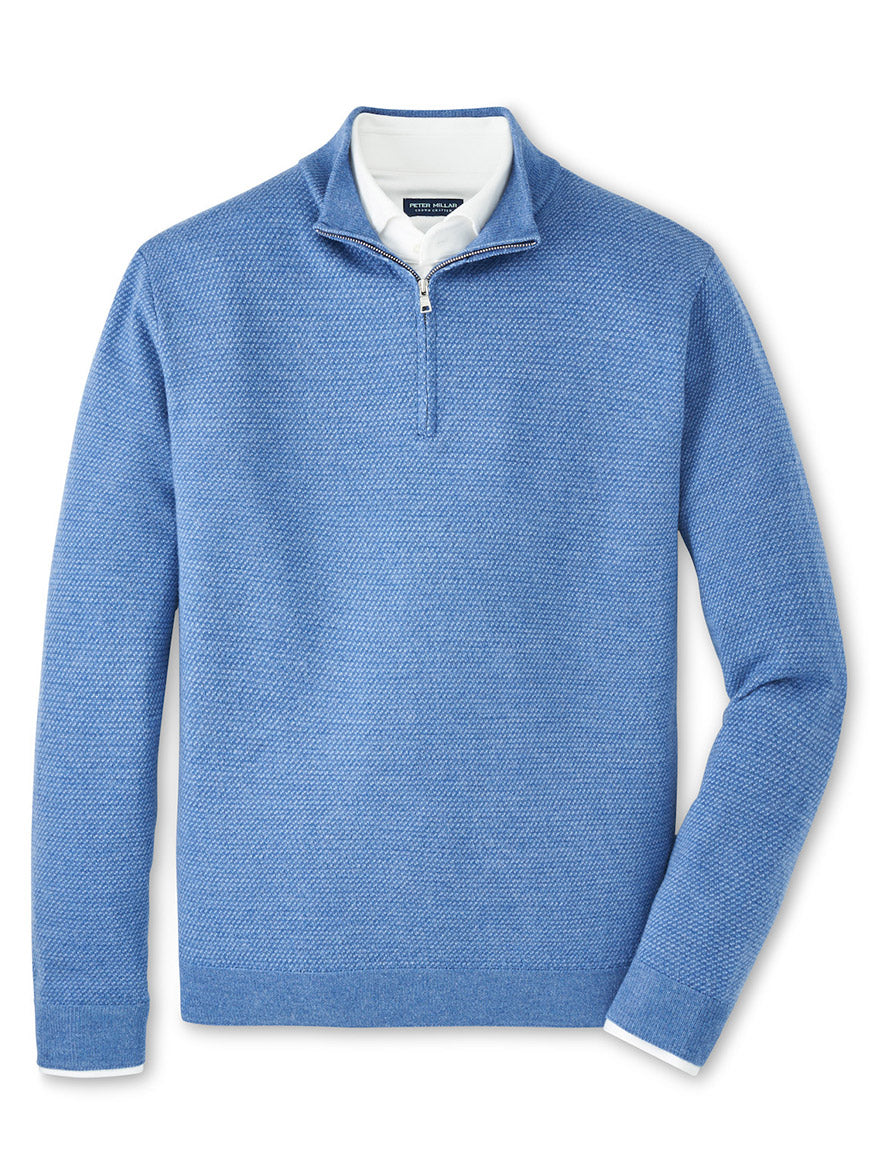 The Peter Millar Keene Quarter-Zip Sweater in Lunar Blue, a tailored midweight pullover, is displayed layered over a white collared shirt on a flat, white background.