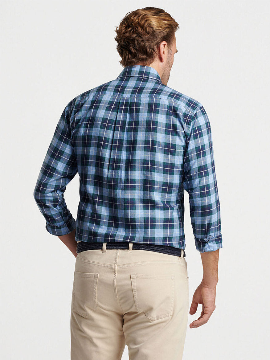 A man is shown from the back wearing a Peter Millar Langley Summer Soft Cotton Sport Shirt in Cottage Blue plaid paired with perfectly tailored beige pants in a classic fit.