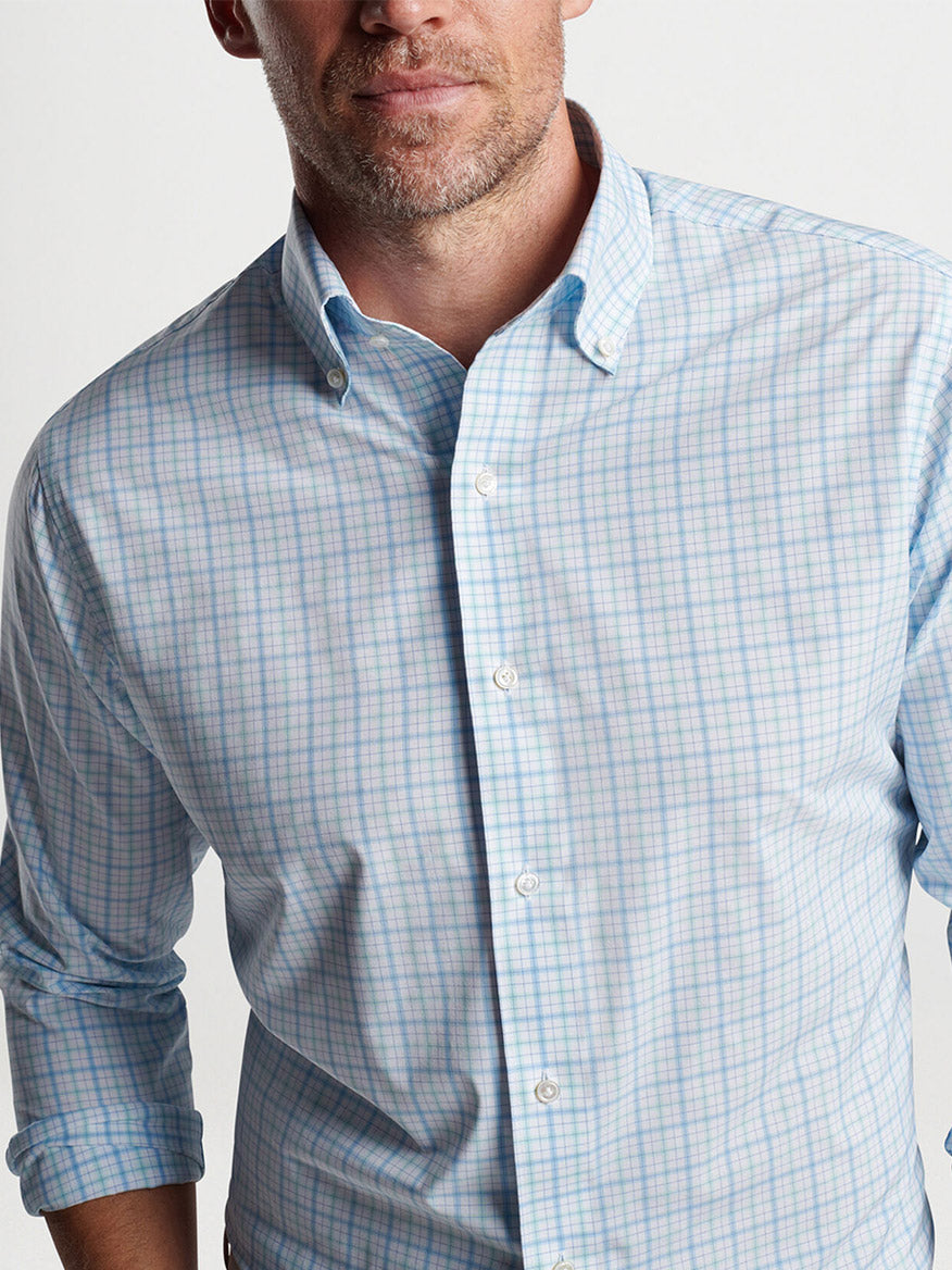 Man wearing a light blue checked Peter Millar Rollins Performance Poplin Sport Shirt in Iced Aqua with tailored fit.