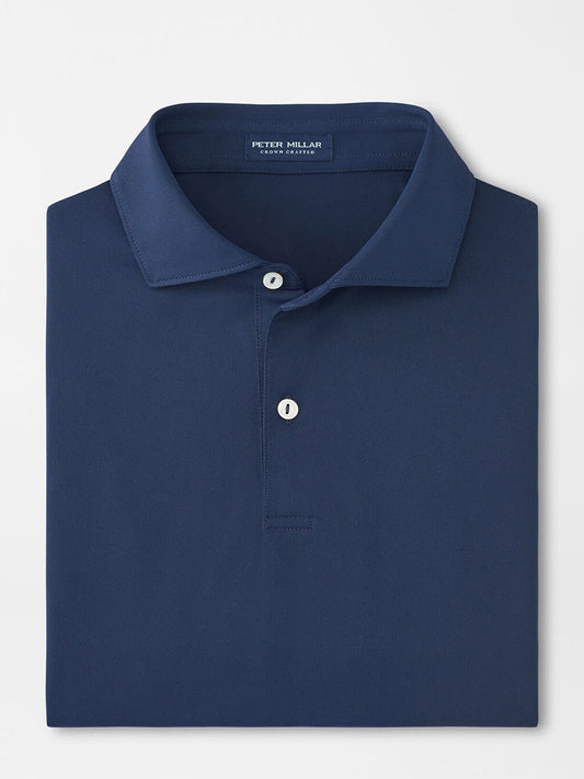 The Peter Millar Soul Performance Mesh Polo in navy features a neatly folded design with an Edwin Spread Collar and two buttons. Crafted for performance, its four-way stretch makes it ideal for any occasion, showcased elegantly on a white background.